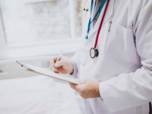 Physician noting down symptoms of a patient