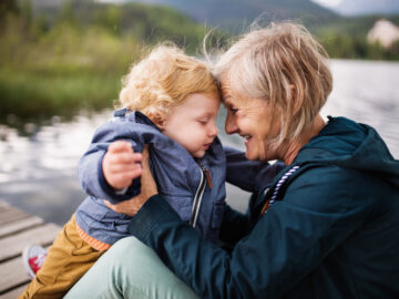 Senior woman with little boy at the lake.